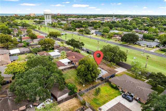 an aerial view of residential houses with outdoor space and lake view