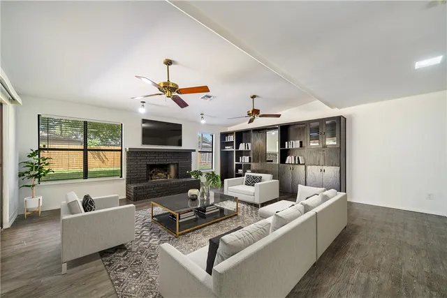 a living room with fireplace furniture and a large window