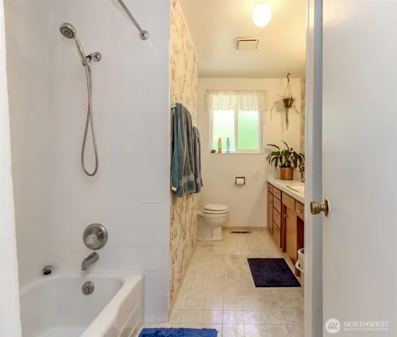 a bathroom with a tub sink and mirror