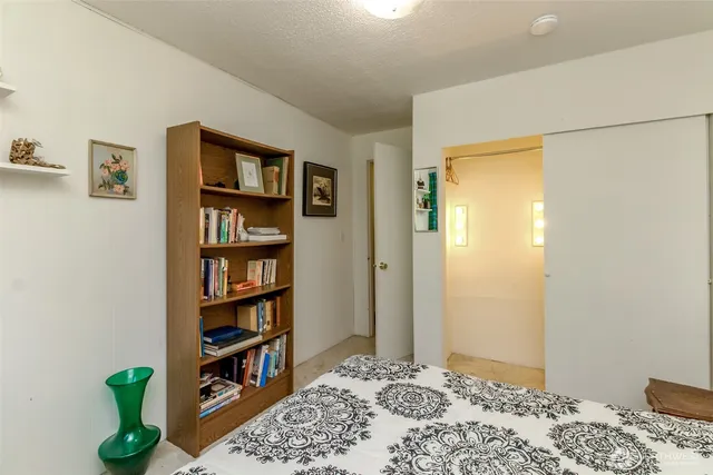 a bedroom with bed and a book shelf