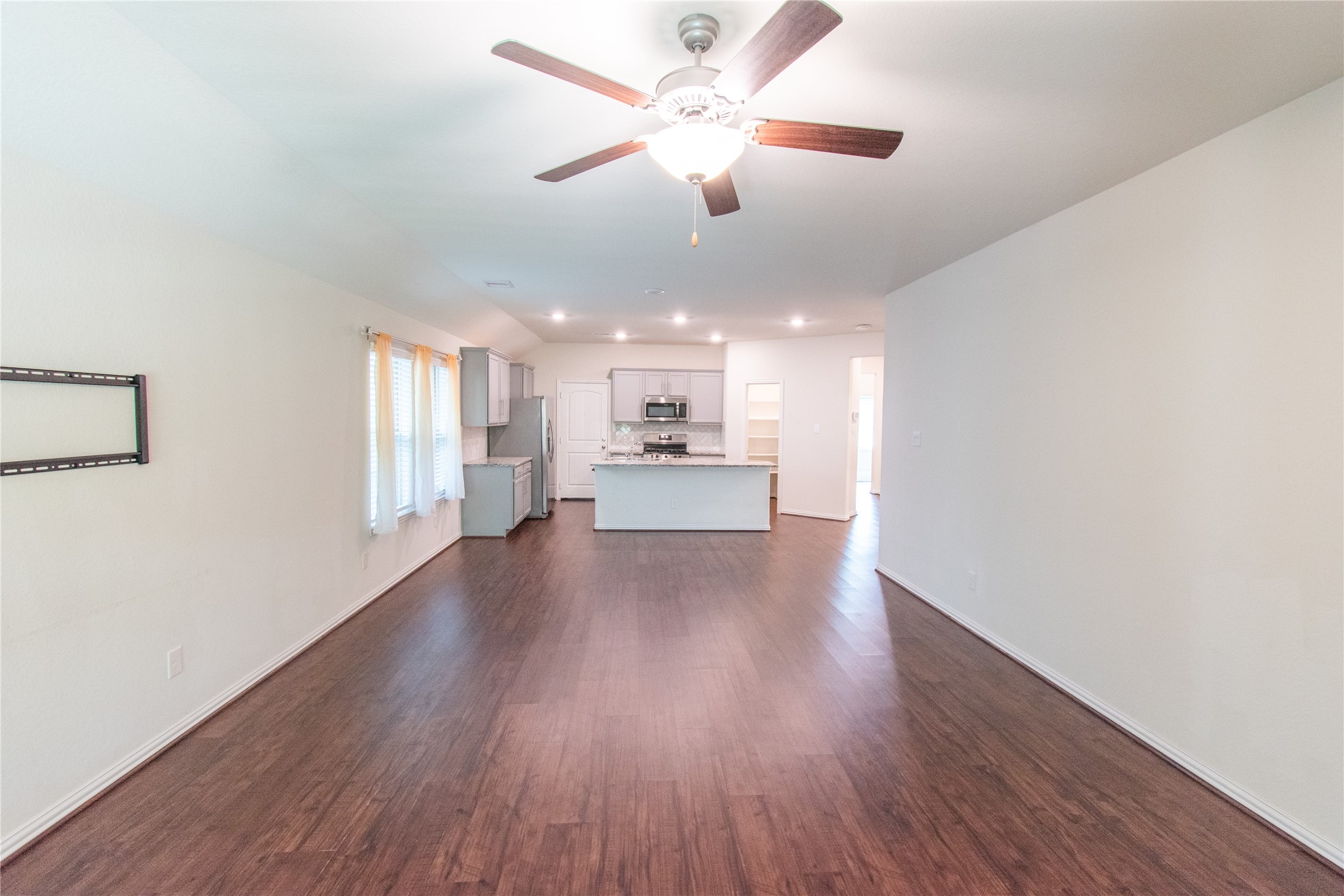 4639 Sequoia Echo Drive Spring, TX 77386 - Photo 11 of 30 a view of an empty room with a kitchen and wooden floor