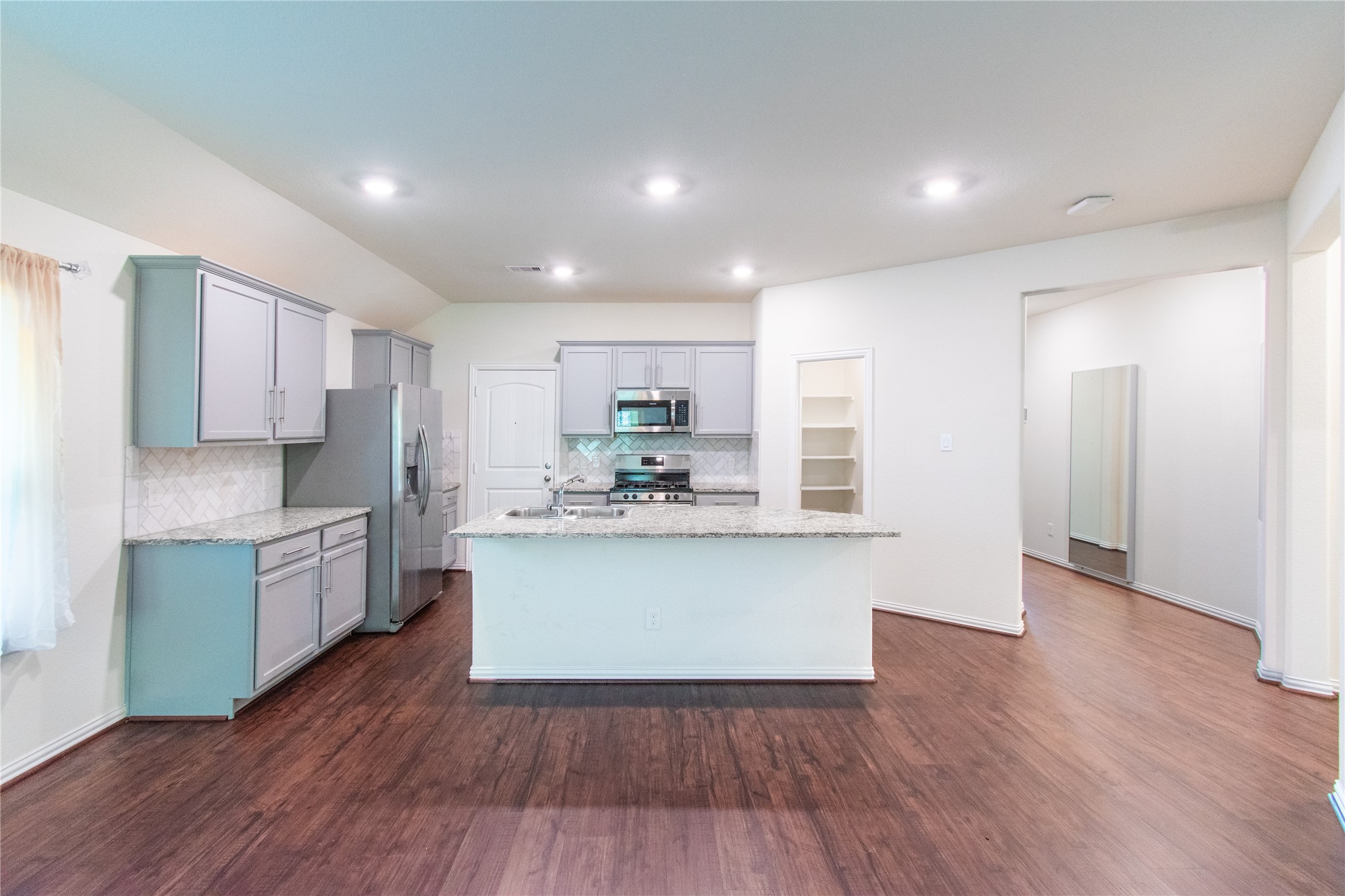 4639 Sequoia Echo Drive Spring, TX 77386 - Photo 7 of 30 a kitchen with kitchen island wooden floors appliances and cabinets