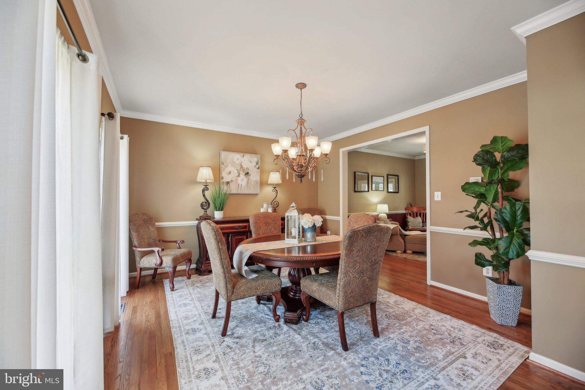 10204 Crosscut Way Damascus, MD 20872 - Photo 12 of 65 a dining room with furniture potted plants and wooden floor