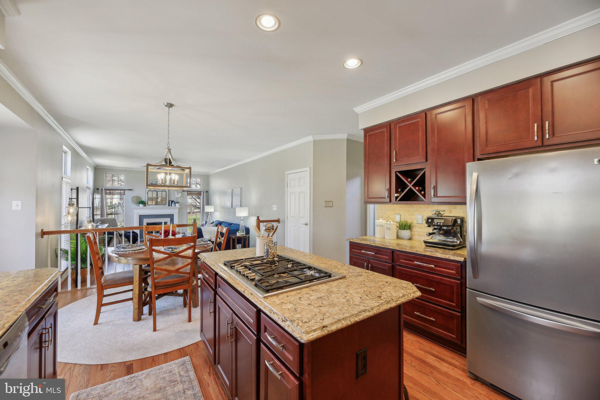10204 Crosscut Way Damascus, MD 20872 - Photo 13 of 65 a kitchen with a stove a refrigerator and wooden cabinets