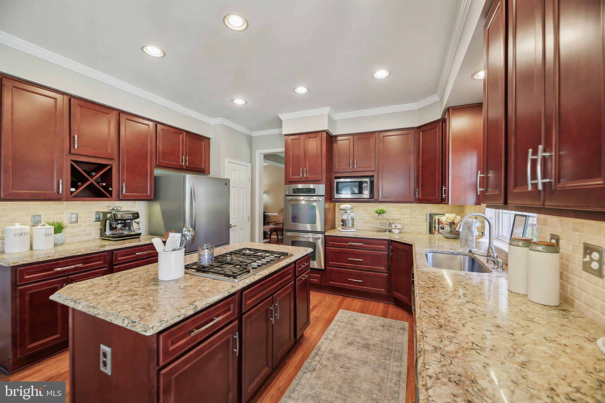 10204 Crosscut Way Damascus, MD 20872 - Photo 14 of 65 a kitchen with stainless steel appliances granite countertop a stove refrigerator sink and cabinets