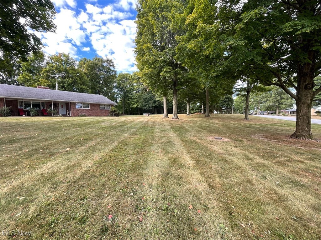 5990 Meese Road Northeast Louisville, OH 44641 - Photo 9 of 16 View of grassy yard with a porch and view of wooded area