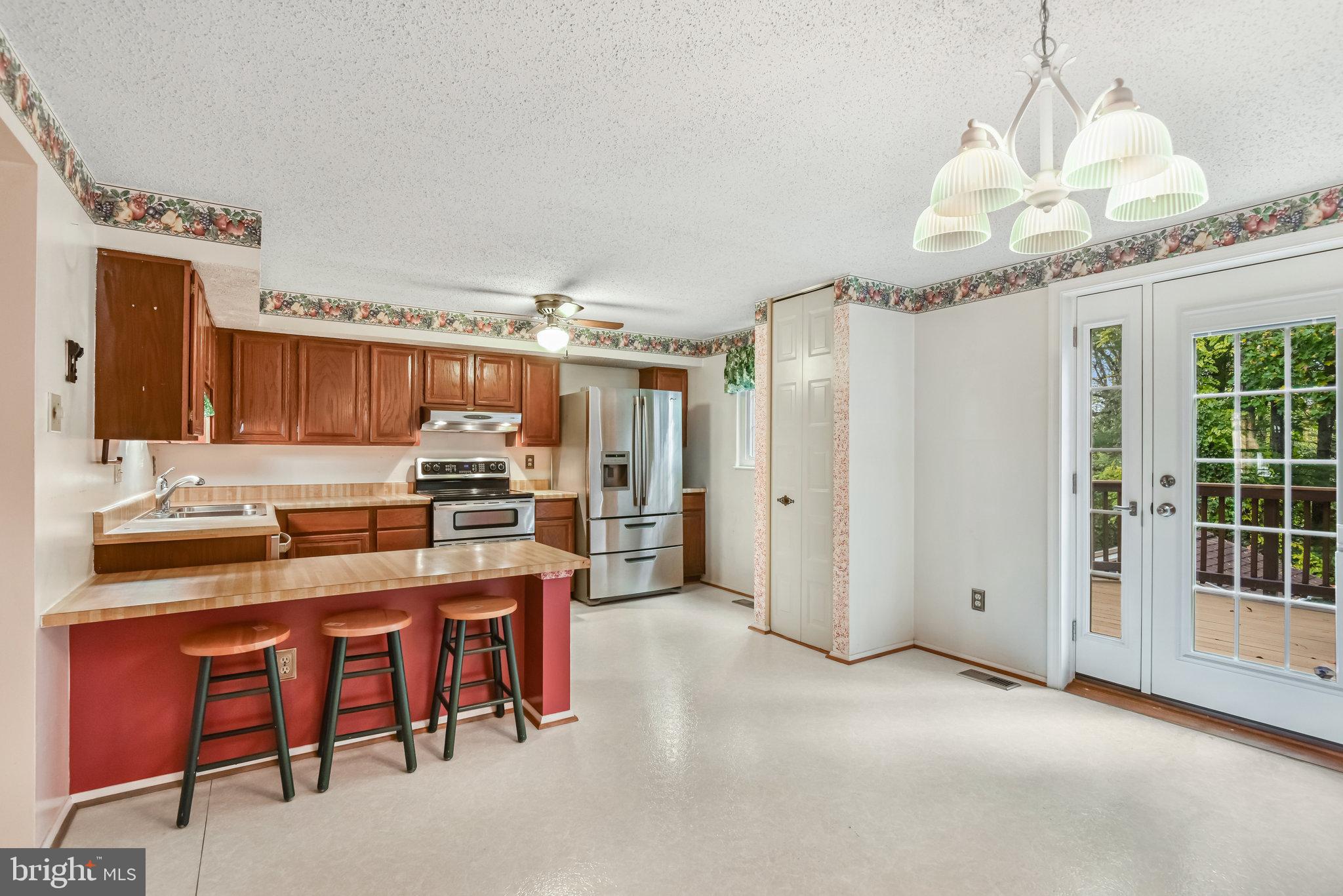 5825 High Bluff Court Burke, VA 22015 - Photo 14 of 52 a kitchen with kitchen island granite countertop a sink cabinets and refrigerator