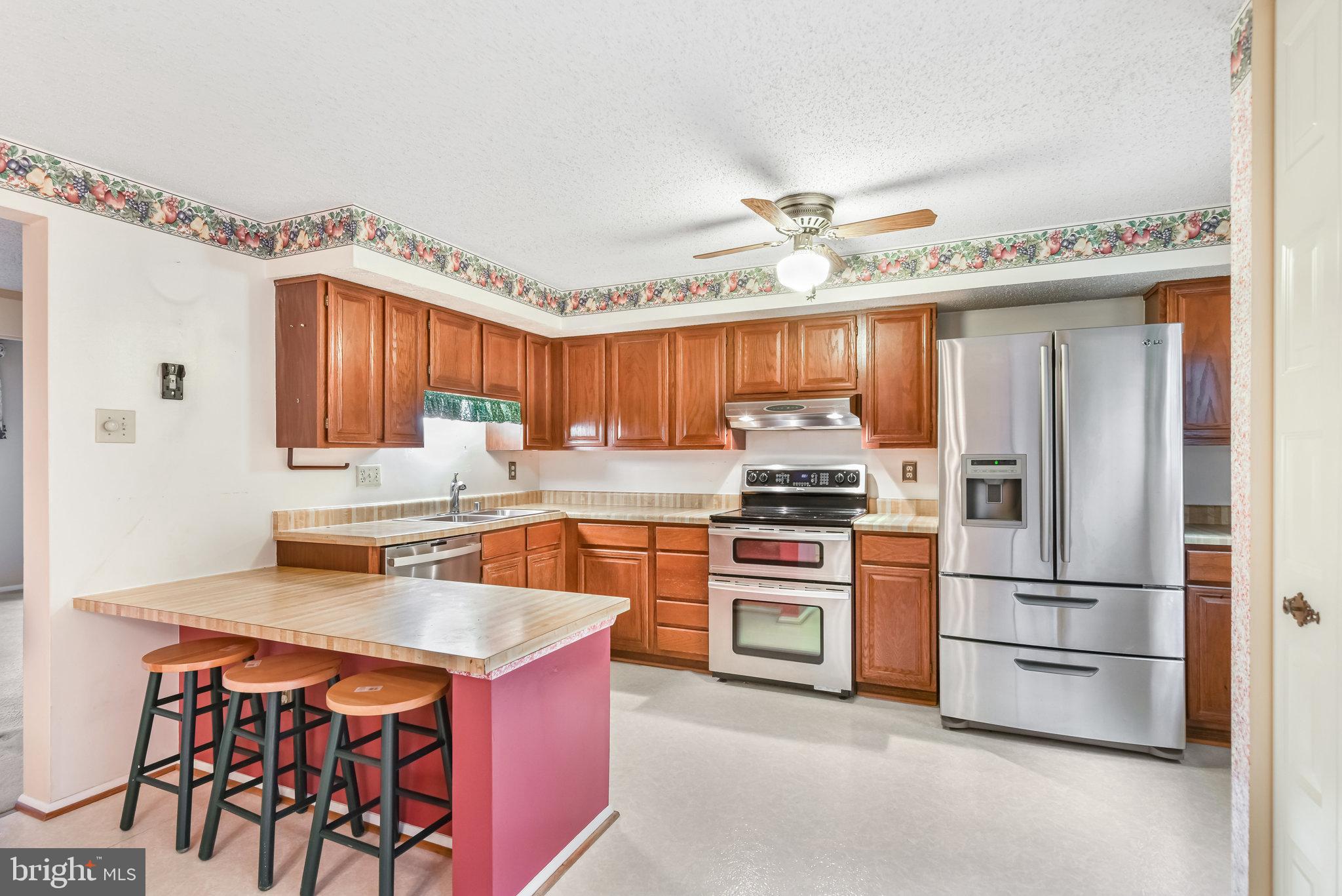 5825 High Bluff Court Burke, VA 22015 - Photo 16 of 52 a kitchen with stainless steel appliances granite countertop a stove refrigerator and a sink