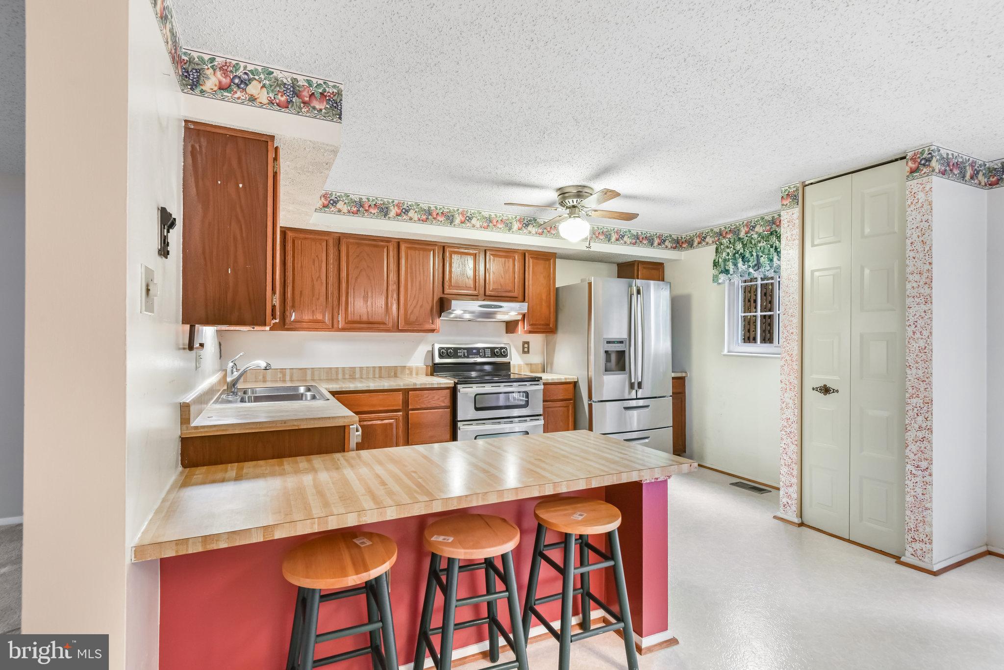 5825 High Bluff Court Burke, VA 22015 - Photo 17 of 52 a kitchen with stainless steel appliances granite countertop a sink and refrigerator