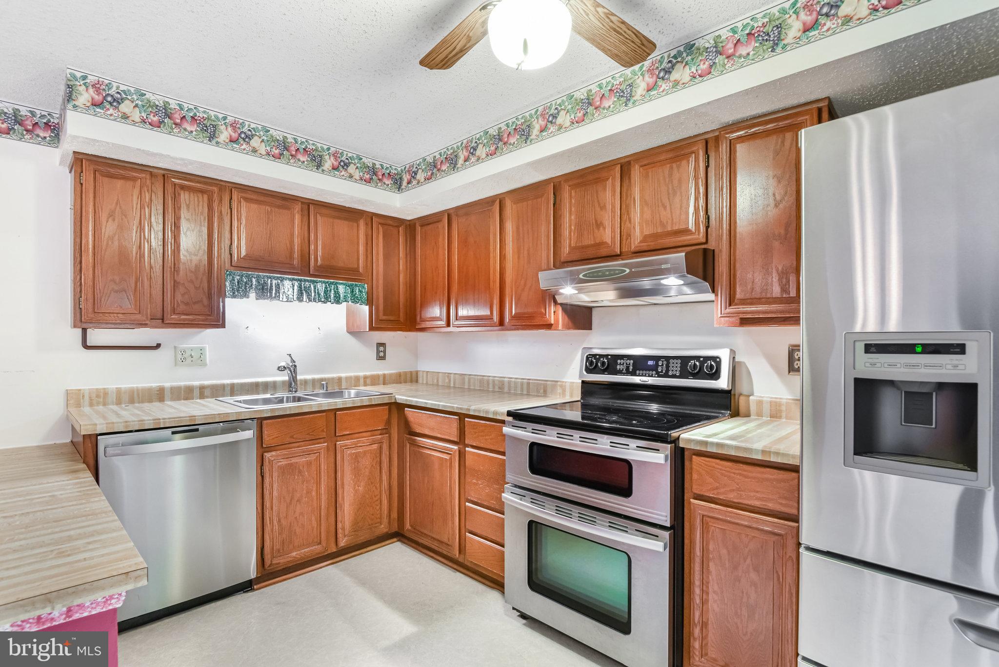 5825 High Bluff Court Burke, VA 22015 - Photo 18 of 52 a kitchen with cabinets stainless steel appliances and wooden floor