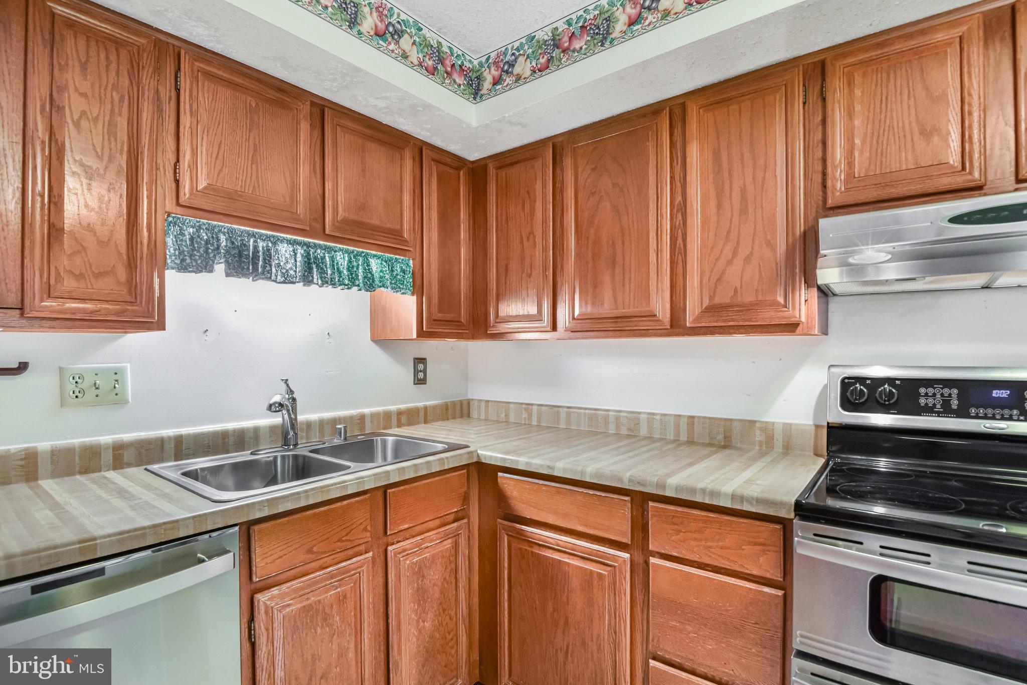 5825 High Bluff Court Burke, VA 22015 - Photo 20 of 52 a kitchen with stainless steel appliances granite countertop a sink stove and cabinets