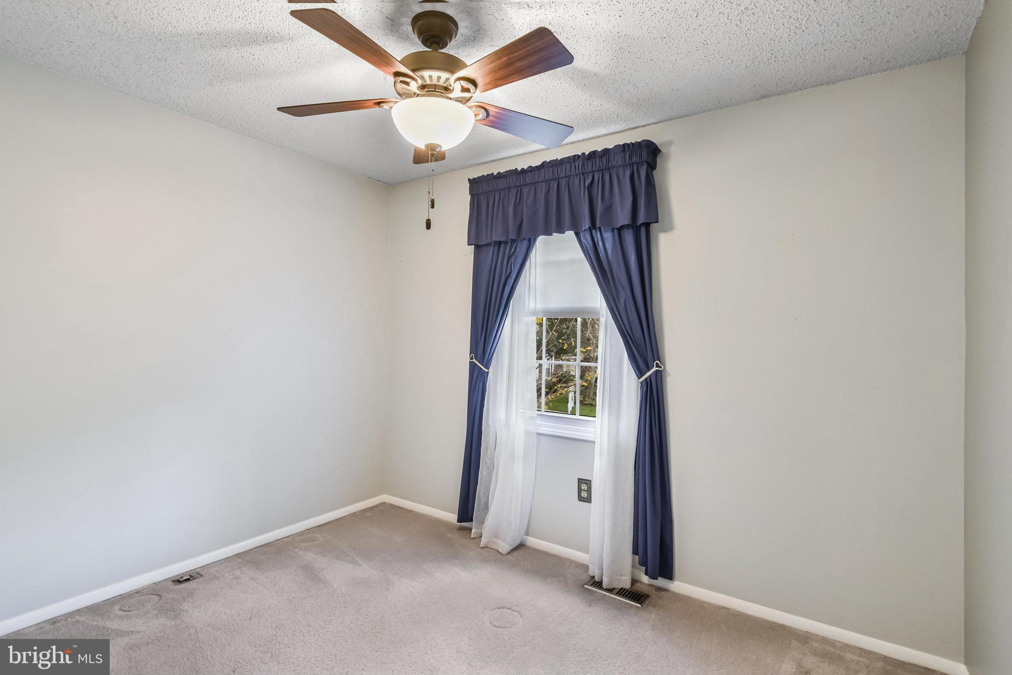 5825 High Bluff Court Burke, VA 22015 - Photo 25 of 52 an empty room with ceiling fan and window