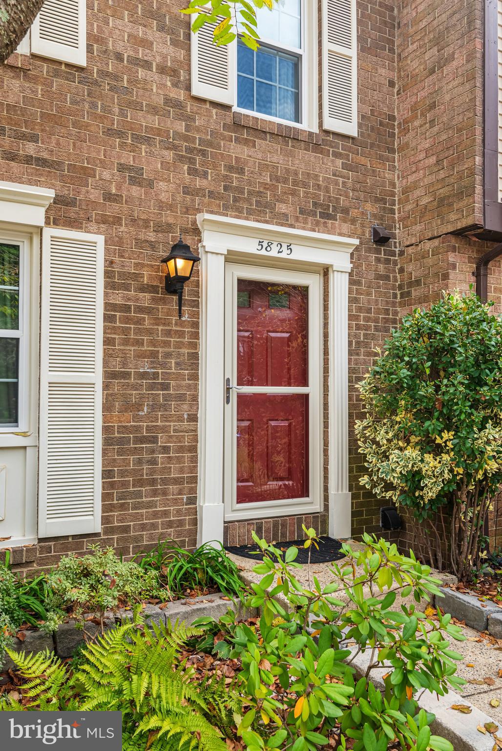 5825 High Bluff Court Burke, VA 22015 - Photo 8 of 52 a view of a brick house with potted plants