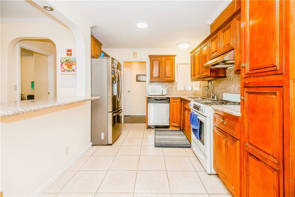 4635 Merced Avenue Baldwin Park, CA 91706 - Photo 4 of 18 a large kitchen with stainless steel appliances granite countertop a refrigerator and a stove