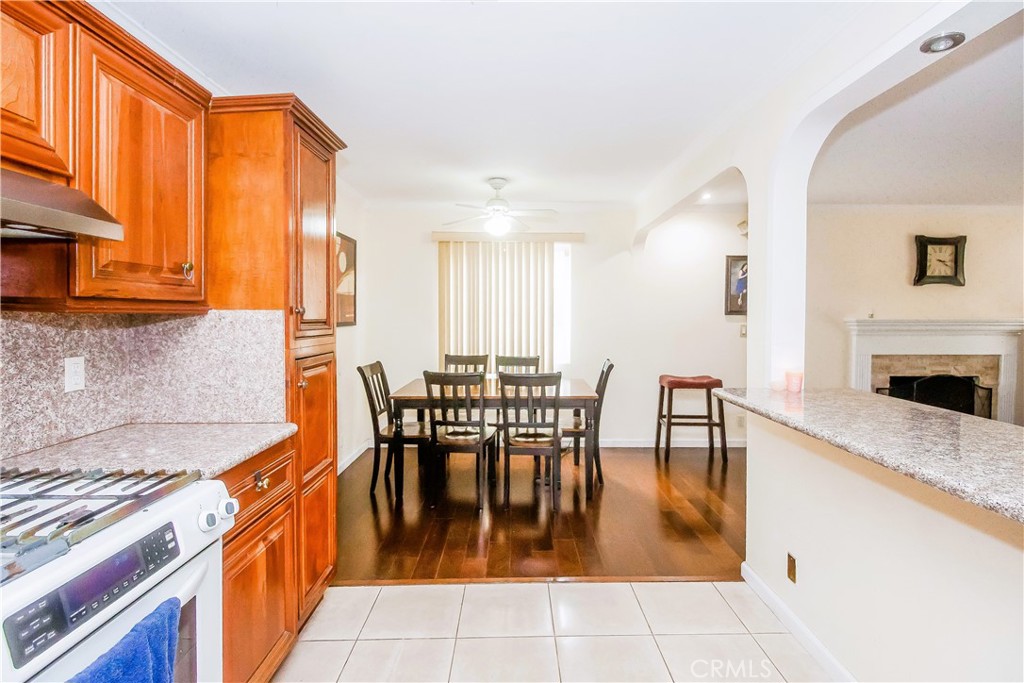 4635 Merced Avenue Baldwin Park, CA 91706 - Photo 5 of 18 a dining hall with stainless steel appliances granite countertop a stove a sink a dining table and chairs with wooden floor