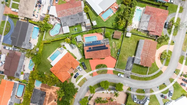 an aerial view of a houses with a swimming pool