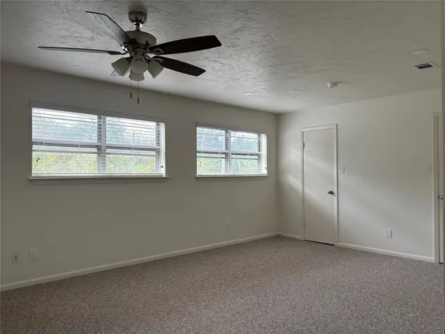 a bathroom with a granite countertop bathtub shower sink vanity and toilet