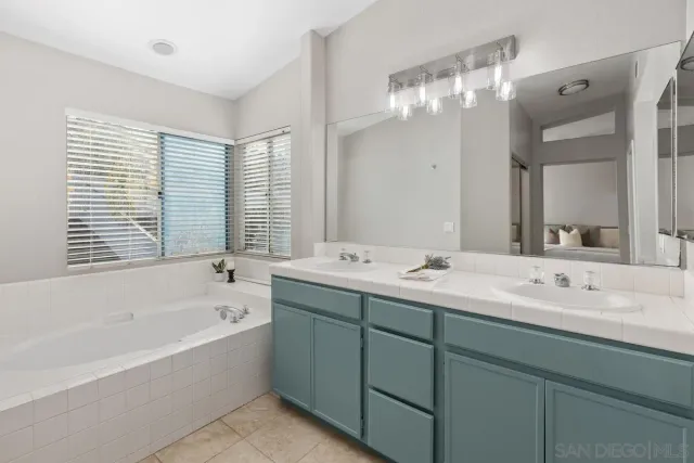 a bathroom with a tub sink and mirror