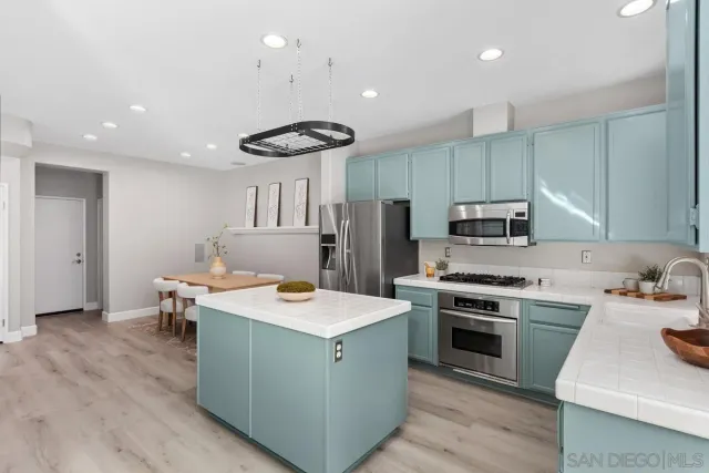 a kitchen with a stove a refrigerator and a sink