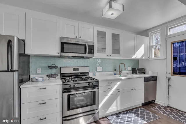 a kitchen with cabinets stainless steel appliances a sink and a counter space
