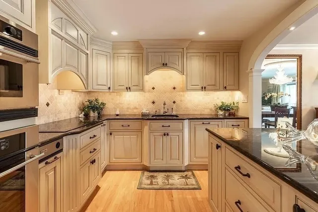 a kitchen with granite countertop a sink stainless steel appliances and cabinets