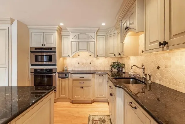 a kitchen with granite countertop a sink stainless steel appliances and cabinets