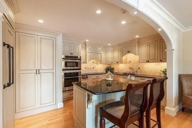 a kitchen with stainless steel appliances granite countertop a stove refrigerator and cabinets