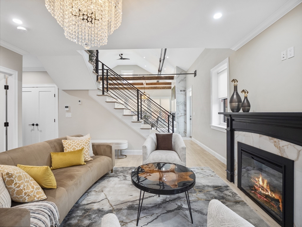 140 Middlesex Street, Unit 3 Lowell, MA 01852 - Photo 1 of 30 a living room with furniture a fireplace and a chandelier