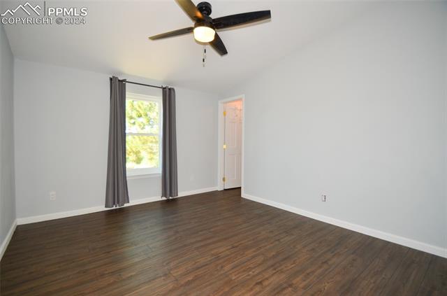 34115 Big Springs Road Yoder, CO 80864 - Photo 21 of 35 Empty room with lofted ceiling, ceiling fan, and dark hardwood / wood-style floors