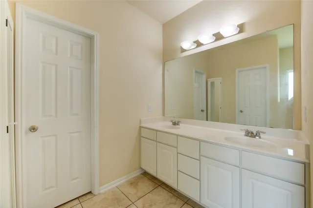 a bathroom with a double vanity sink and a mirror