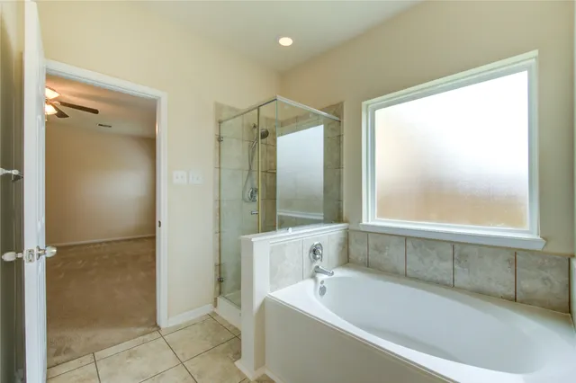 a bathroom with a large tub a shower and view