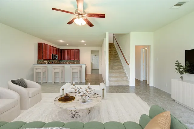 a living room with stainless steel appliances kitchen island granite countertop furniture and a view of kitchen