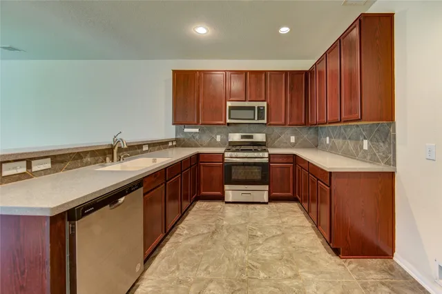 a kitchen with stainless steel appliances granite countertop a sink stove and cabinets