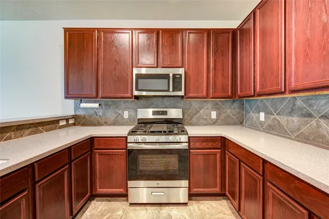 a kitchen with wooden cabinets and a stove top oven