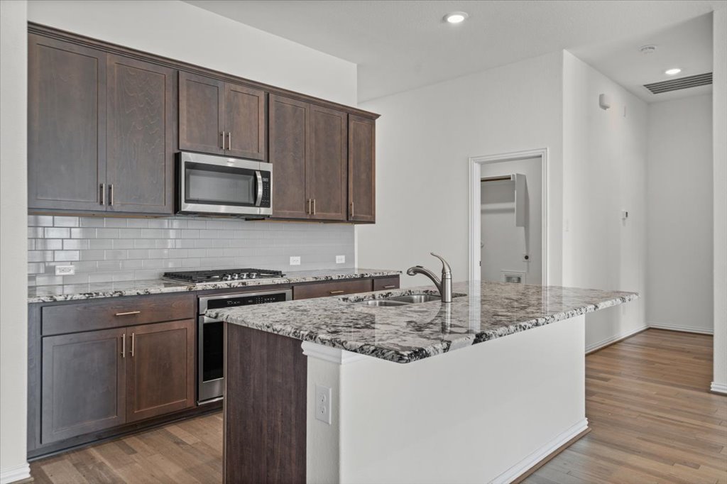 277 Spinnaker Loop Kyle, TX 78640 - Photo 11 of 38 A well-appointed kitchen showcasing elegant granite countertops and modern stainless steel appliances.
