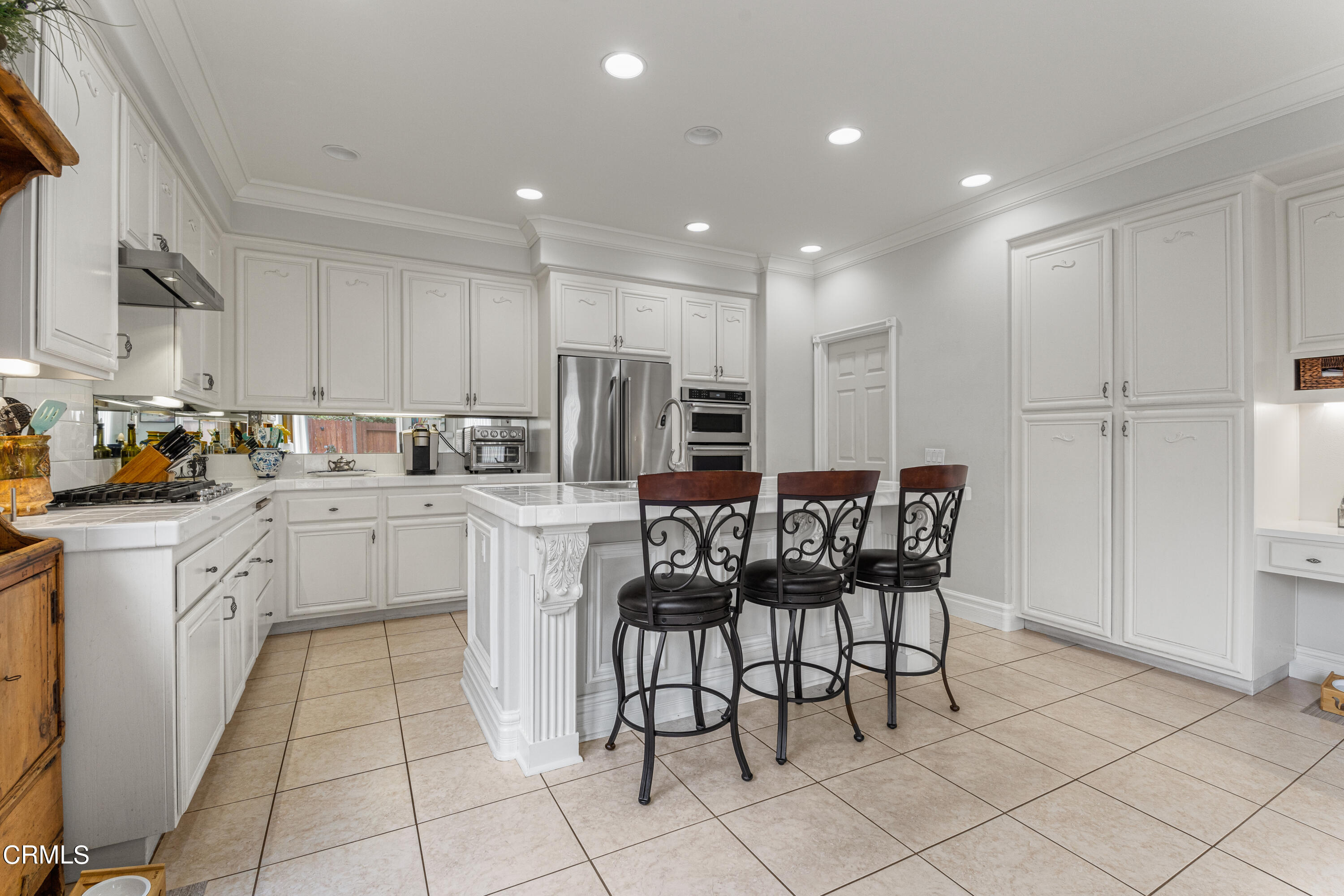 1555 Corte Olivas Camarillo, CA 93012 - Photo 11 of 45 a kitchen with a dining table chairs appliances and cabinets