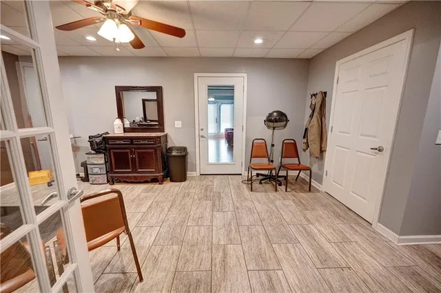 an empty room with windows and fan