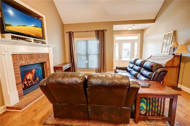 a living room with furniture a flat screen tv and a fireplace