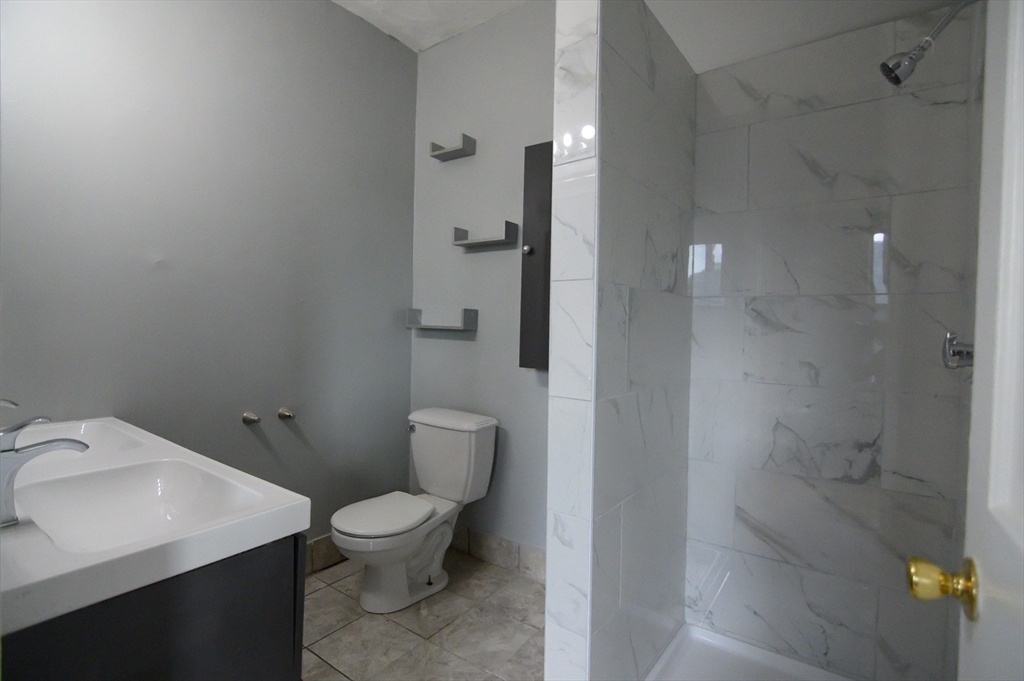 4 Burton Avenue, Unit 3 Boston, MA 02119 - Photo 12 of 17 a bathroom with a toilet a sink and shower