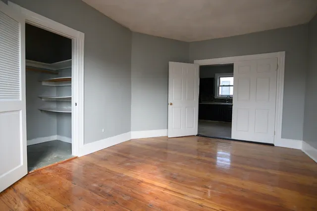 a view of an empty room with closet and a window
