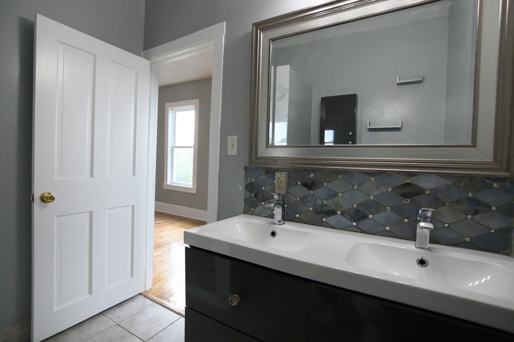 4 Burton Avenue, Unit 3 Boston, MA 02119 - Photo 4 of 17 a bathroom with a sink and a mirror