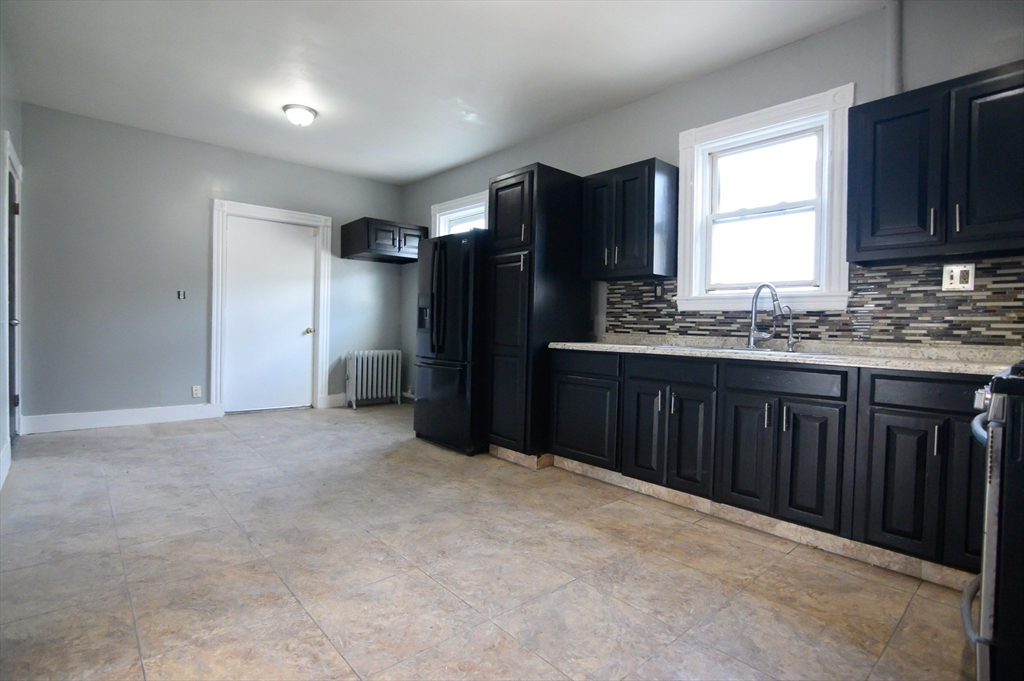 4 Burton Avenue, Unit 3 Boston, MA 02119 - Photo 5 of 17 a kitchen with stainless steel appliances granite countertop a refrigerator and a sink