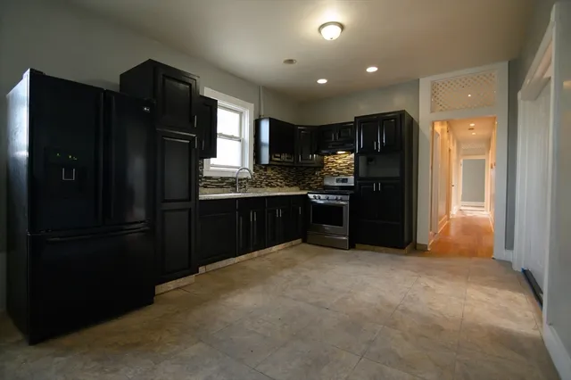 a kitchen with stainless steel appliances granite countertop a refrigerator and a sink