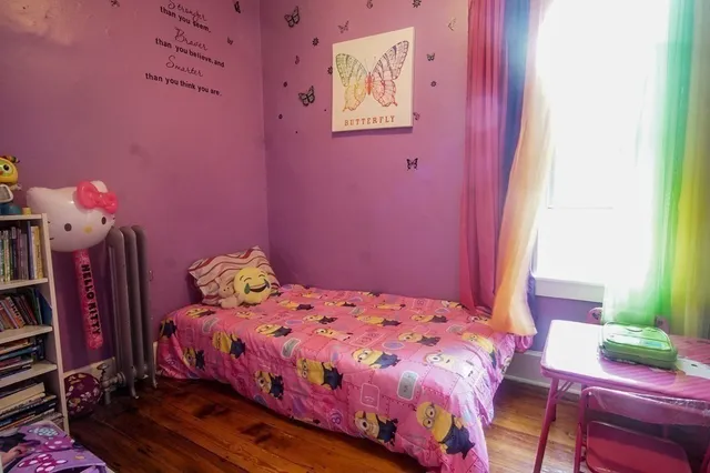 a bedroom with a bed a dresser and a window