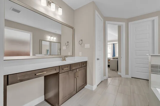 a spacious bathroom with a granite countertop sink and a mirror