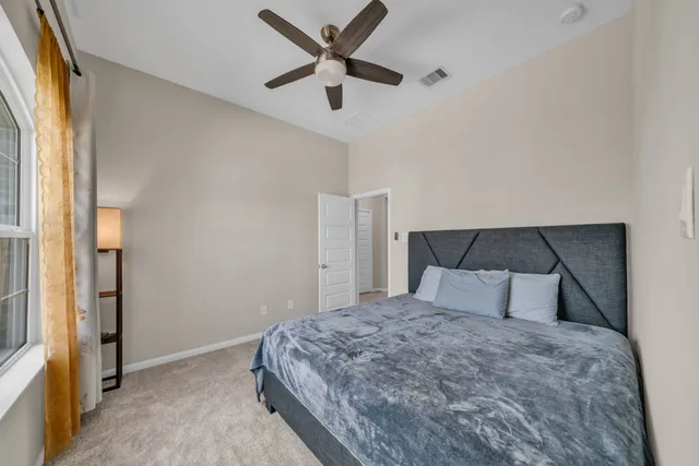a bedroom with a bed and a ceiling fan