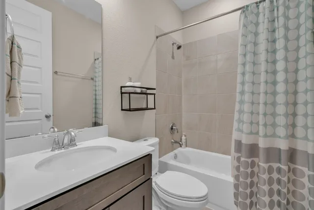 a bathroom with a sink toilet vanity and shower