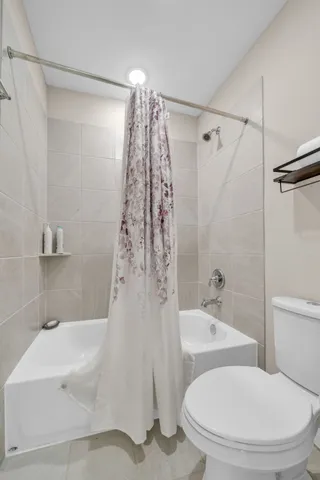 a white bath tub sitting next to a white toilet and sink