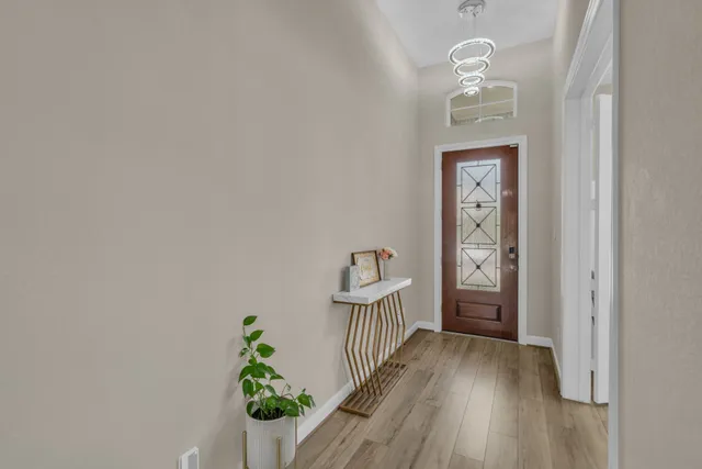 a view of a hallway to a livingroom with wooden floor