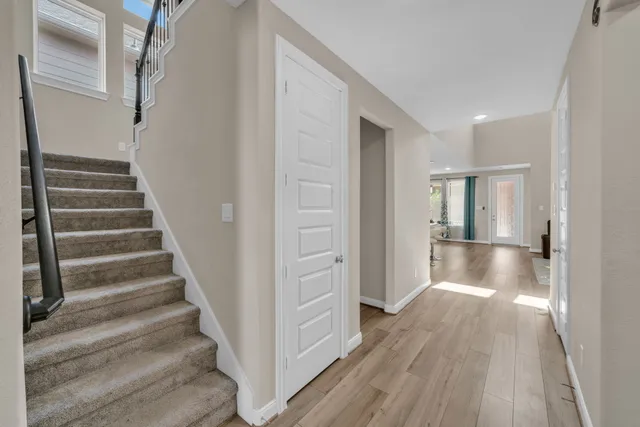 a view of a hallway with wooden floor and entryway